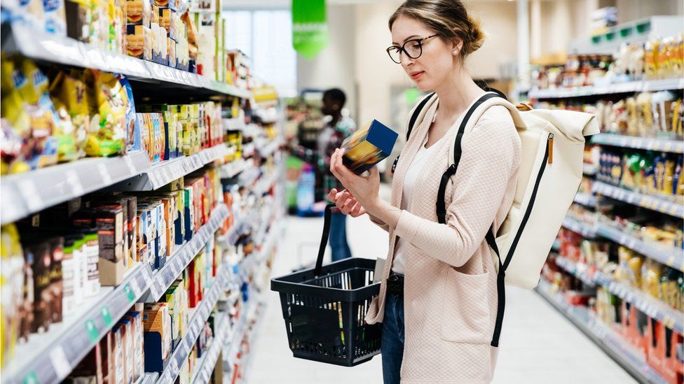 Woman Reading Food Item Label In Supermarket