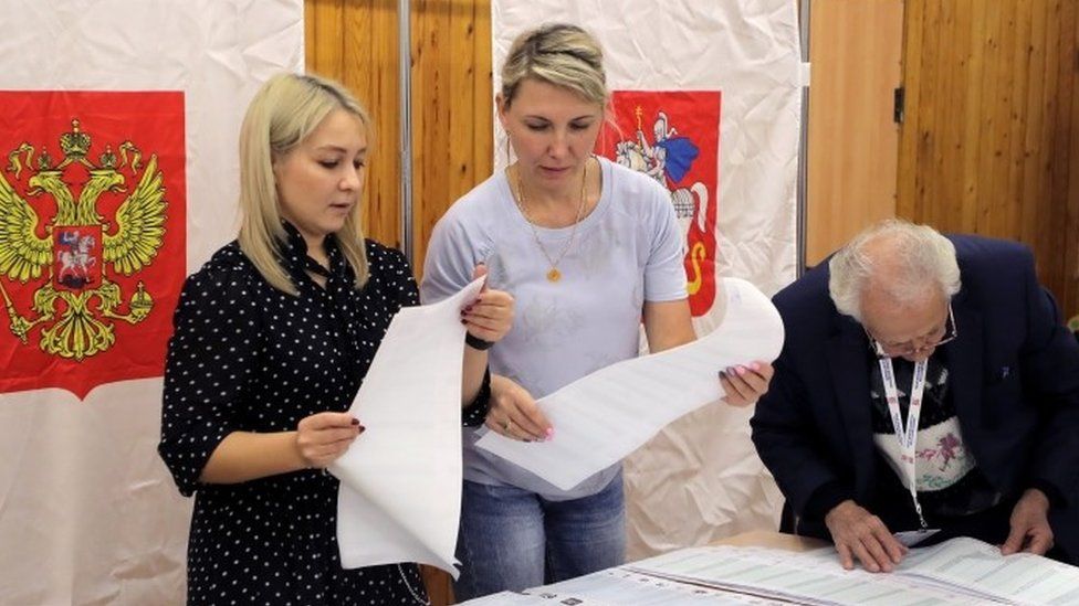 The members of the local election commission count ballots at a polling station
