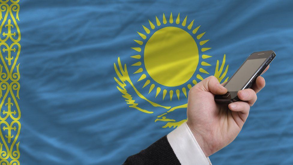 A phone in front of the Kazakhstan flag