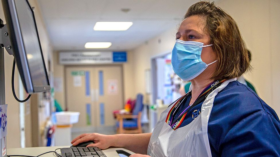 An NHS worker checks patient records on a computer at Nevill Hospital on March 08, 2021 in Abergavenny, Wales
