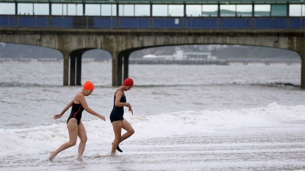 Two swimmers leaving the sea near Boscombe Pier