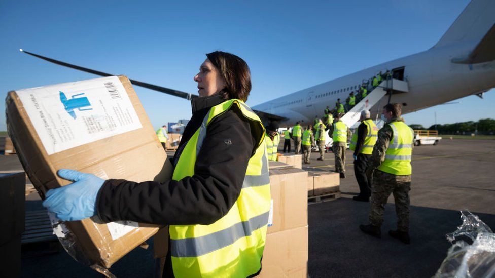 Cardiff airport staff and the military help to unload boxes of PPE from China in May 2020