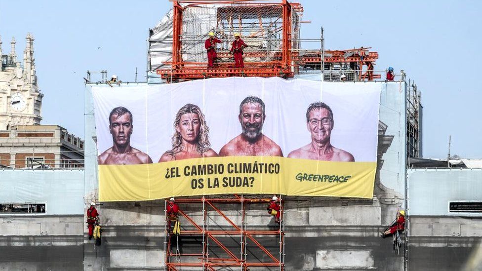 A huge banner picturing the main four candidates running for the upcoming general election (from left) current PM and re-election candidate Pedro Sanchez, current Labor Minister and Sumar party's leader, Yolanda Diaz; far-right Vox's party leader Santiago Abascal, and main opposition Peoples' Party leader, Alberto Nunez Feijoo sweating naked and reading 'Does the climate change give you a damn?' at the facade of Puerta de Alcala monument, in downtown Madrid, Spain, 11 July 2023.