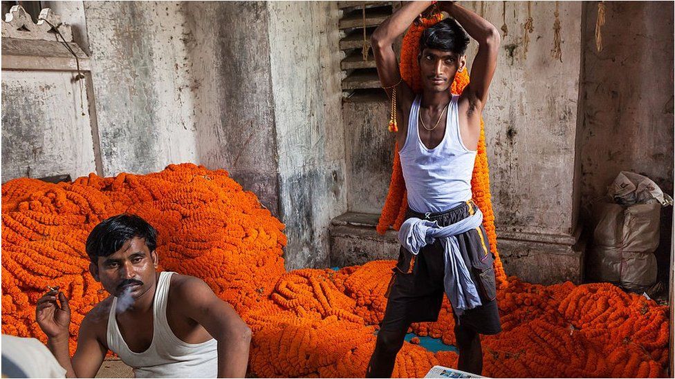 Two workers at a flower market in the eastern Indian city of Kolkata