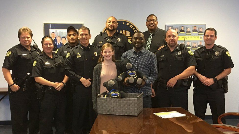 Megan O'Grady presents her Lt. Debra Clayton bear to her son Johnny, along with members of the officer's former squad