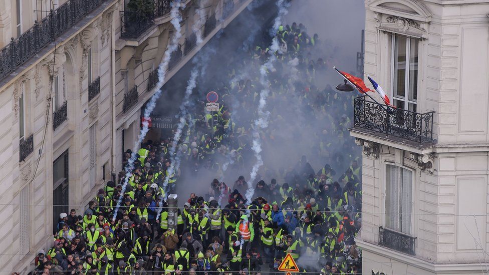 Protesters flee as the police in Paris fire tear gas