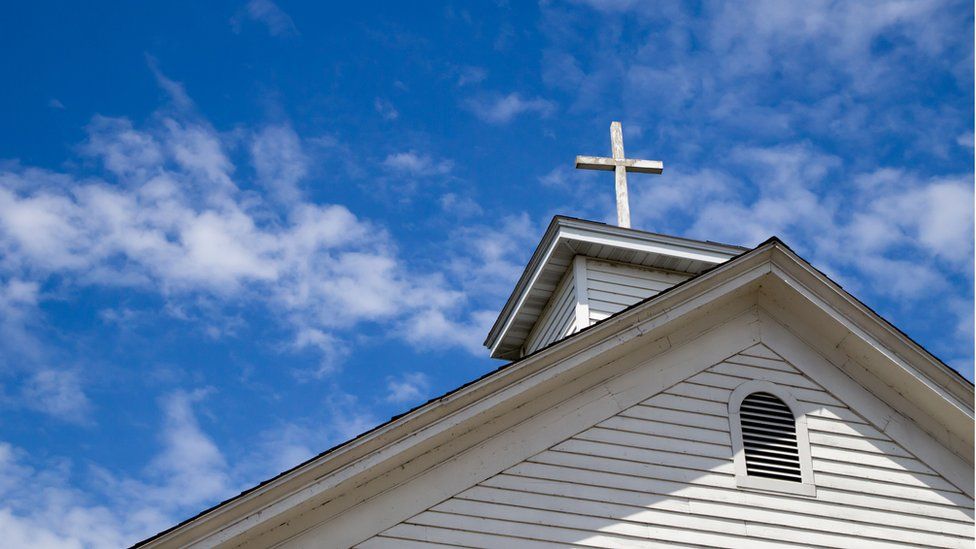 A wooden cross pictured on a church building