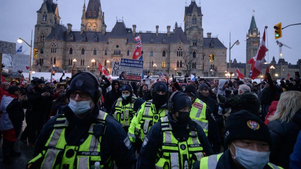 Police officers walk away from demonstrators during a protest by truck drivers over pandemic health rules and the Trudeau government, outside the parliament of Canada in Ottawa on February 11, 2022