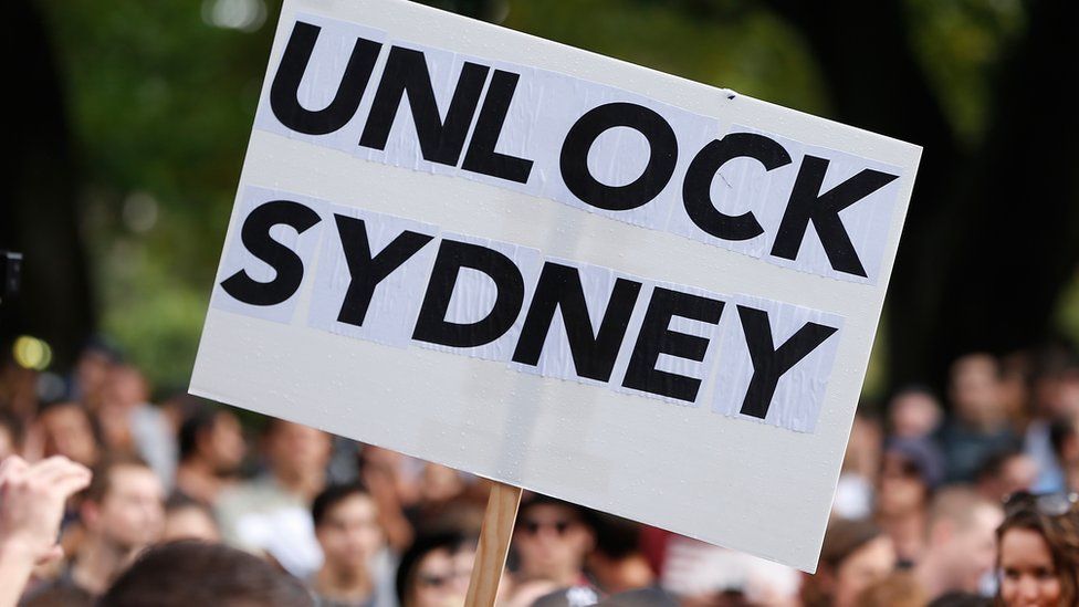 A protester holds a sign saying "UNLOCK SYDNEY" in criticism of the city's laws governing nightlife