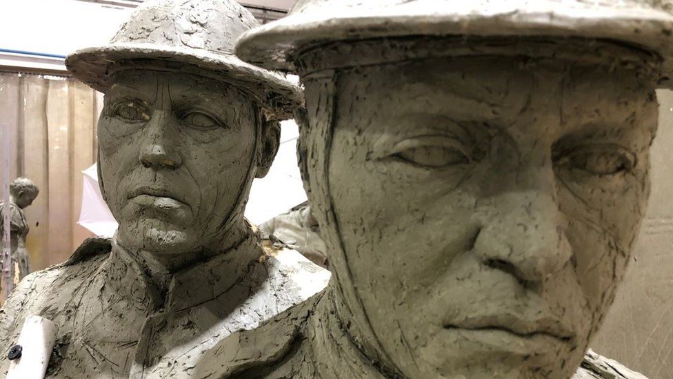 Close up image of two soldiers' faces moulded from clay