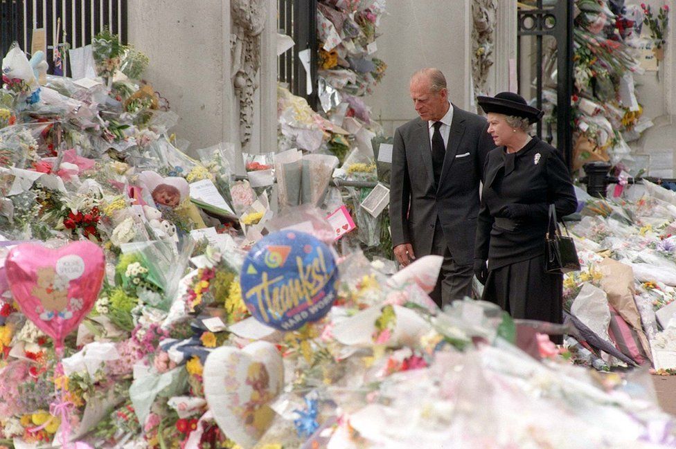 Britain's Queen Elizabeth II and the Duke of Edinburgh view the floral tributes to Diana, Princess of Wales, at Buckingham Palace, 1997