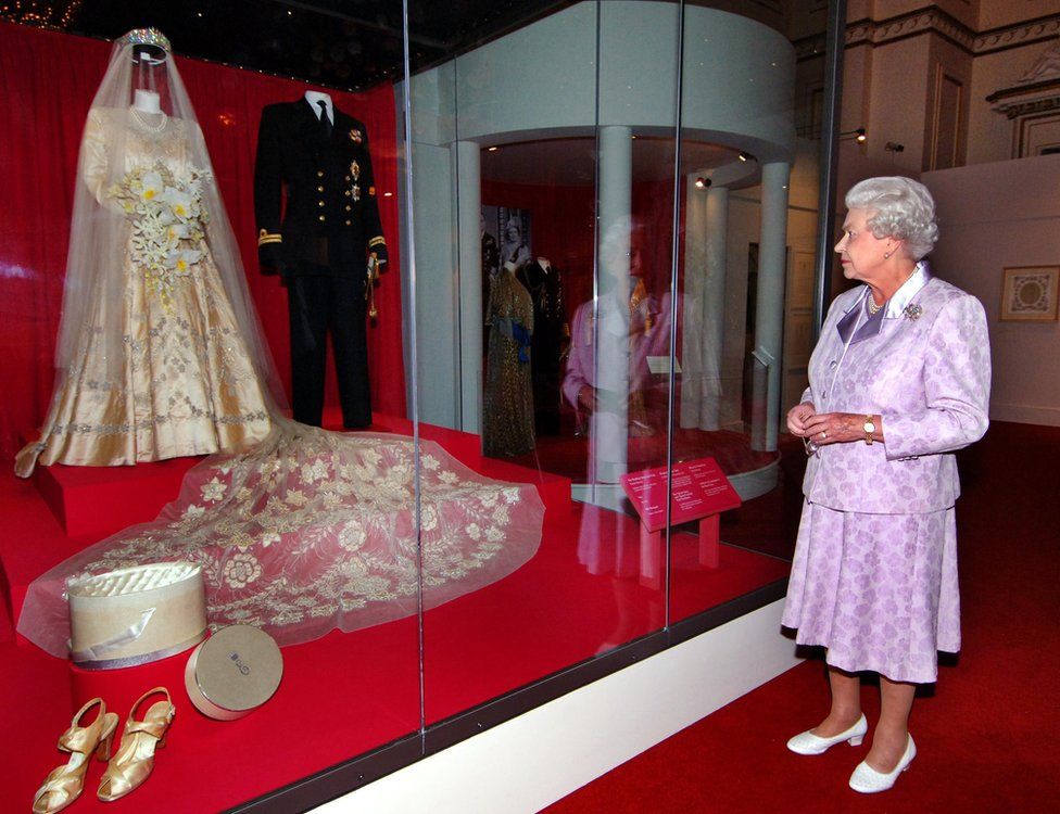 Queen Elizabeth looks at her wedding dress on display