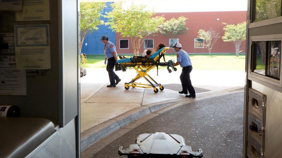 A woman suffering from heat exhaustion is taken into a medical centre in Texas on a gurney