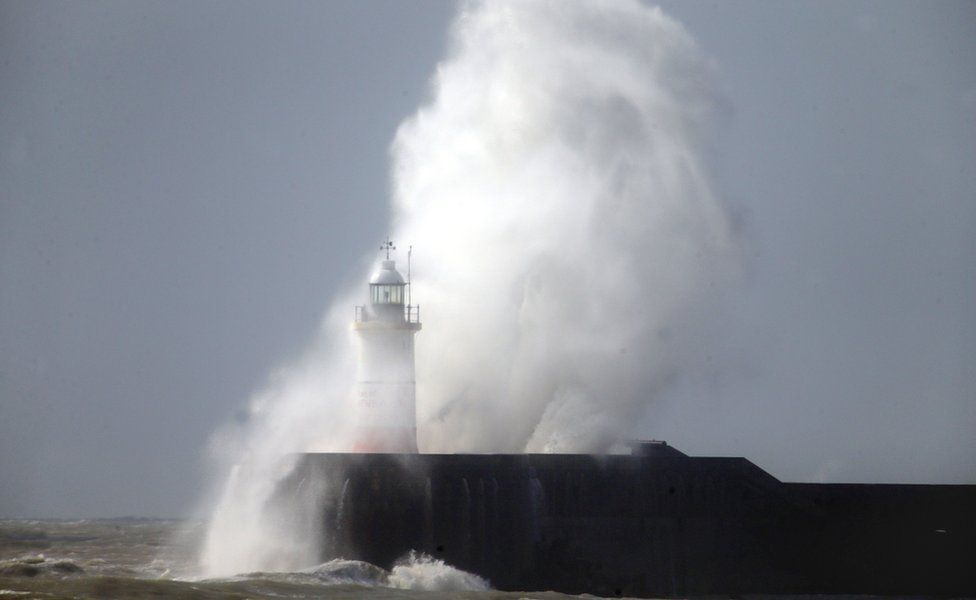 Waves batter the lighthouse at Newhaven in East Sussex