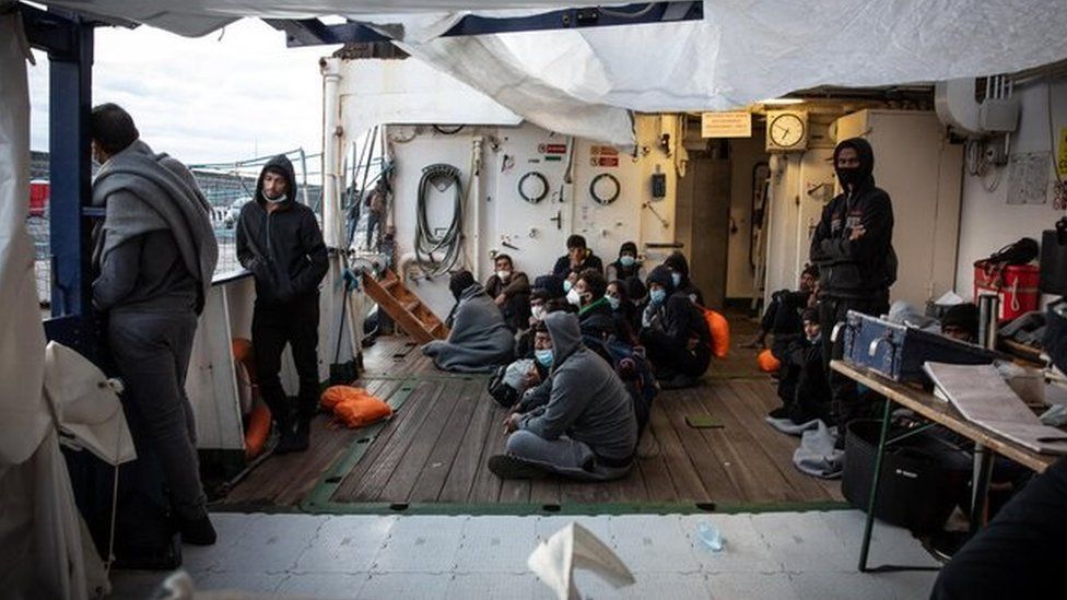 Migrants wait on the boat after they were not allowed to disembark