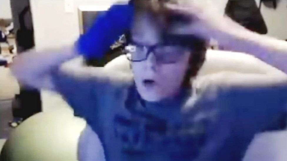 Willis Gibson, a young teenager with eyeglasses places his fingertips to his head and has a look of shock and surprise as he realises he's beaten Tetris.