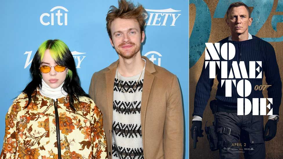 Billie Eilish and Finneas O'Connell with the poster for No Time To Die