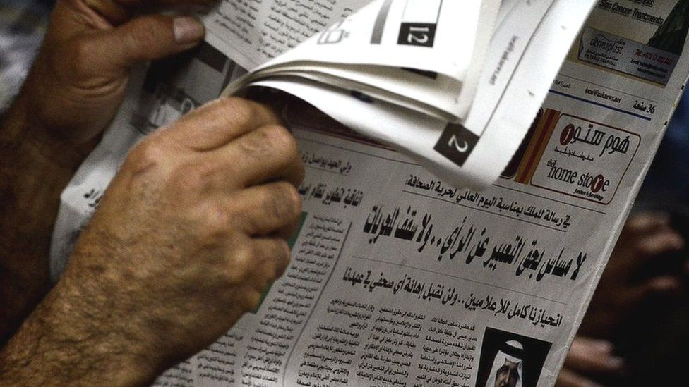 A man reads a newspaper in Bahrain