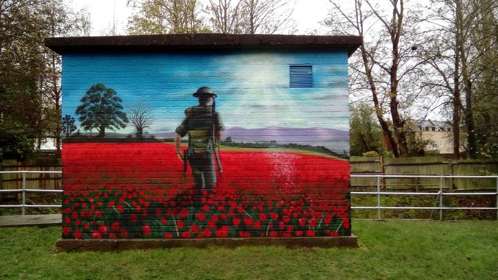 The mural, which shows a soldier from behind who is standing in a poppy field