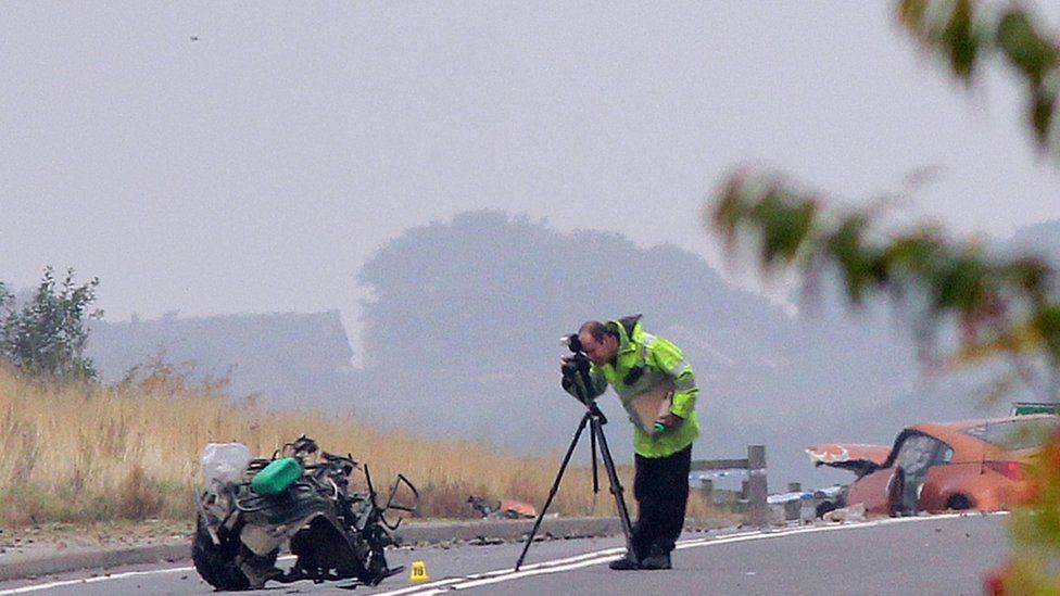 An investigator photographs the wreckage of the quad bike