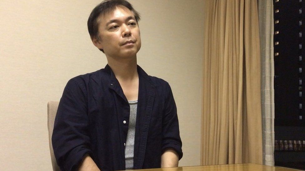 Фотография Коитиро Иидзука 2020 года, сидящего в конференц-зале в Токио