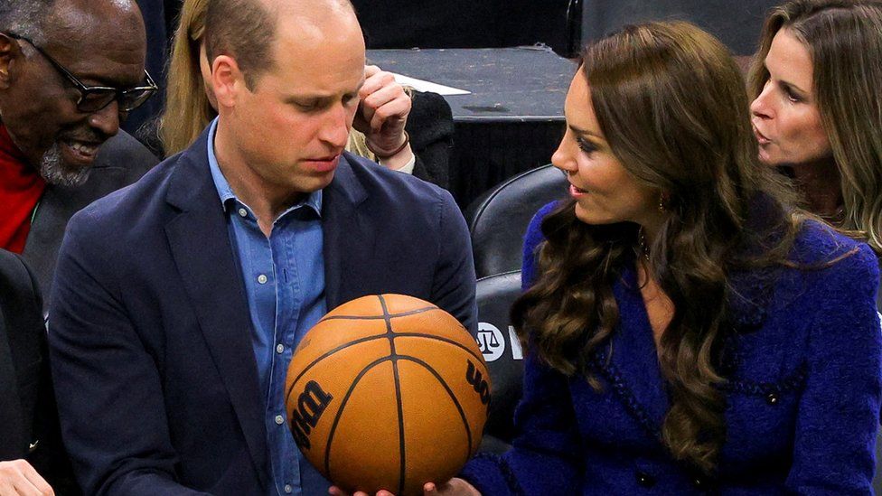Prince William is a handed a basketball by Catherine during the Wednesday night basketball match they attended.