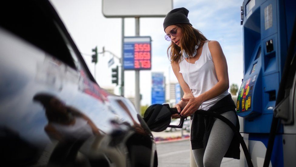 a woman pumping gas