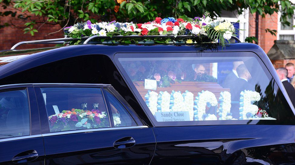 A hearse carries the coffin of John Boreland