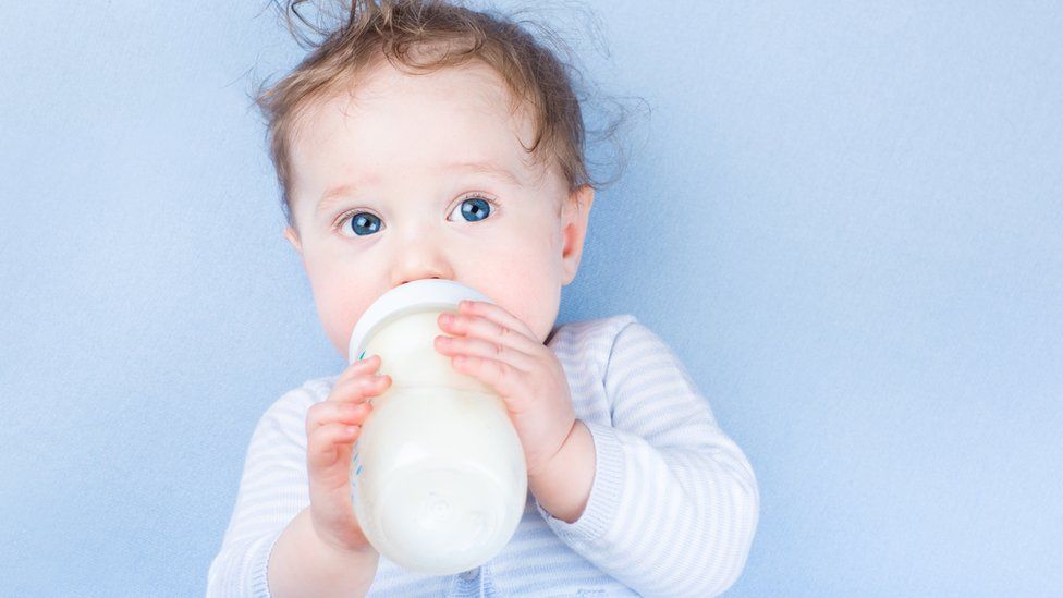 A baby drinking a bottle of formula milk