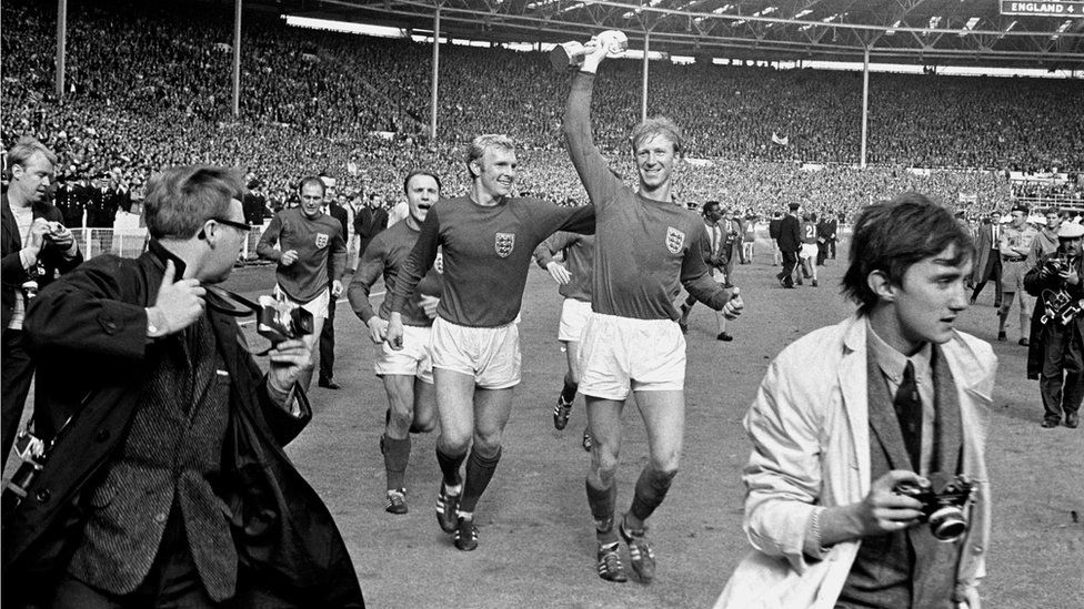 Jack Charlton holds the World Cup trophy aloft on the Wembley pitch in 1966