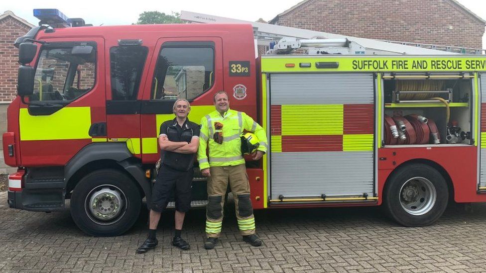 Paul and a firefighter in front of a fire engine in Suffolk