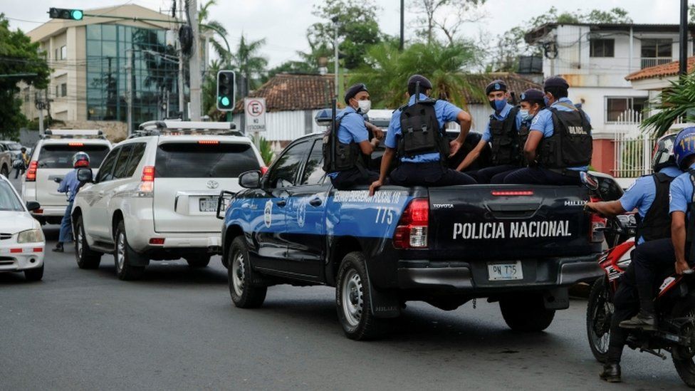 Police officers escort the vehicle of Felix Maradiaga in Managua