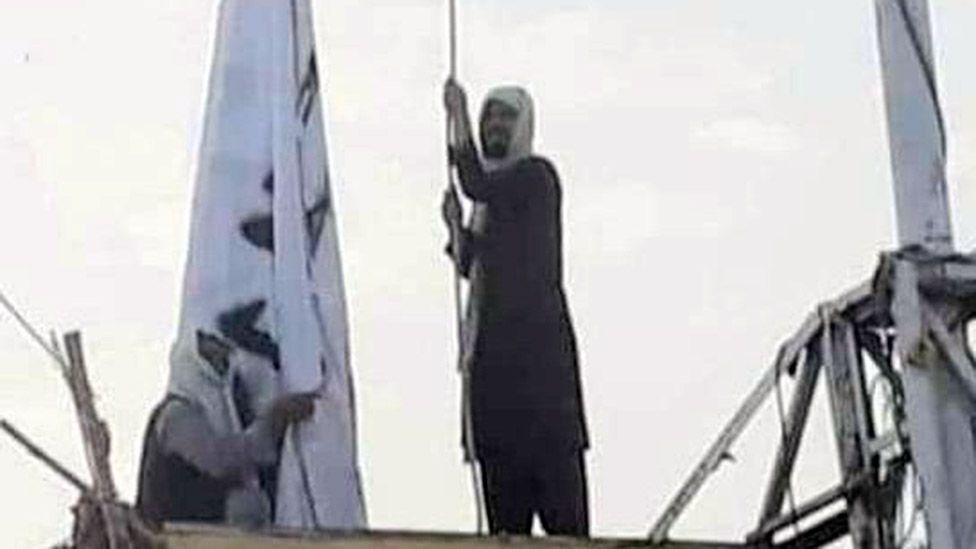 Изображение в соцсети, на котором изображен мужчина, поднимающий флаг Талибана