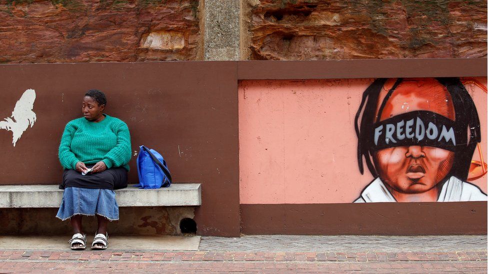 A woman sits next to murals as opposition parties march for the removal of President Jacob Zuma outside the Constitutional Court in Johannesburg, South Africa, May 15, 2017.