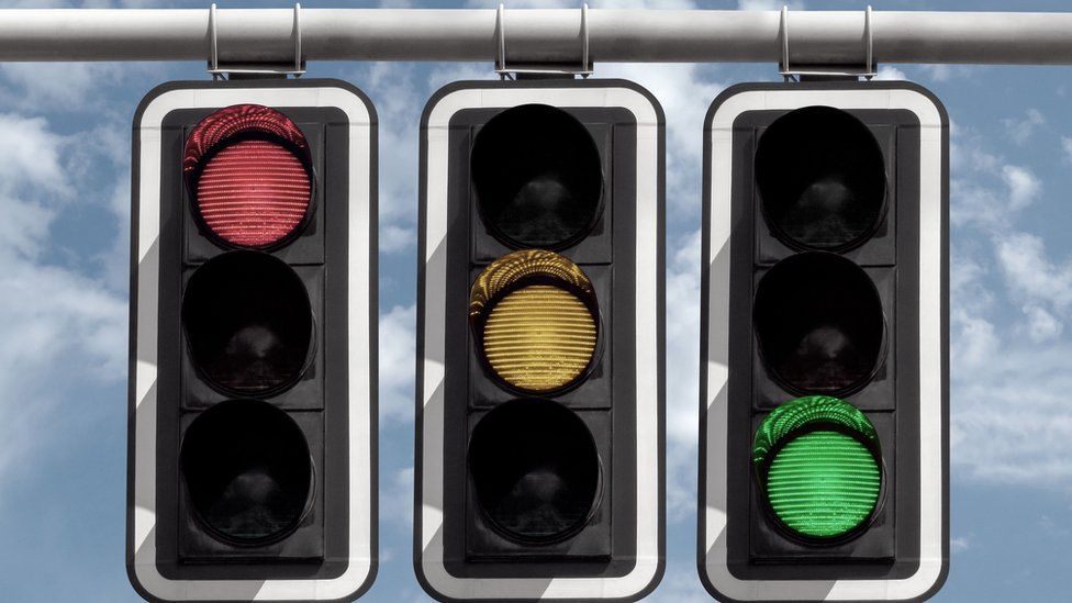 Three traffic lights illuminate the red, yellow and green