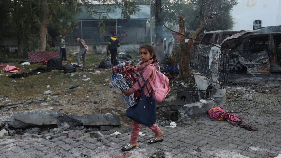A girl walks through the courtyard of the Al-Ahli Arab hospital in Gaza City, where hundreds of people were reportedly killed by an explosion (18 October 2023)