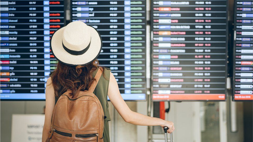 Путешественник смотрит на табло вылета из аэропорта