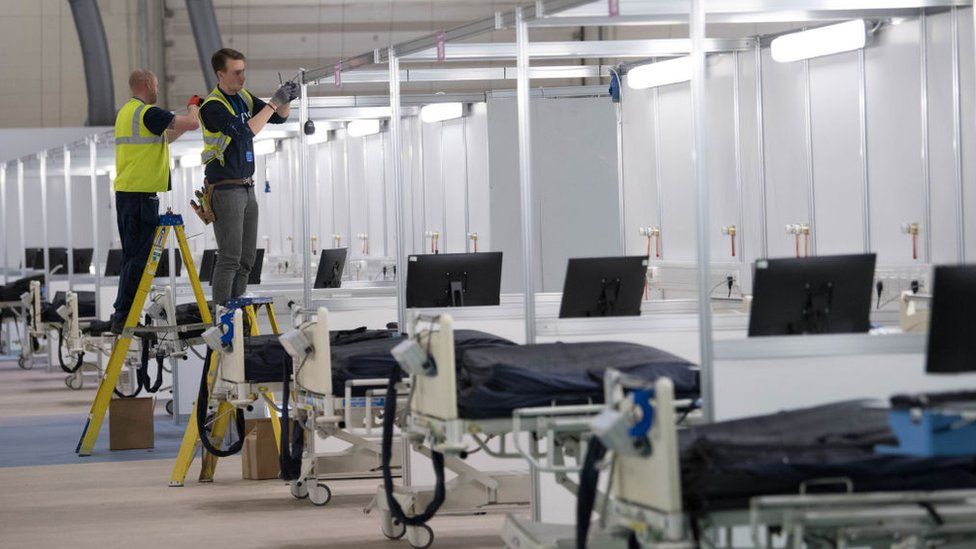 Engineers working to connect a row of ICU beds at the Nightingale hospital in London Excel Centre
