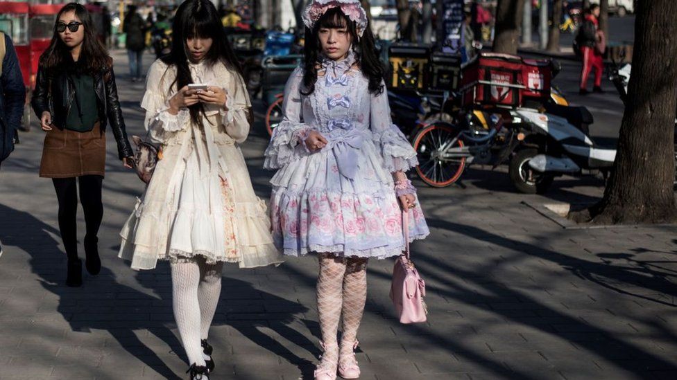 Две девушки в косплей-платьях идут по улице в Пекине