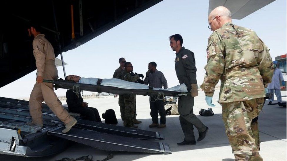Afghan Air forces medical personnel carry an Injured member of the Afghan security forces onto a C-130 military transport plane, prior to transfer for treatment in Kabul, at the Kandahar military Airport, Afghanistan July 9, 2017.