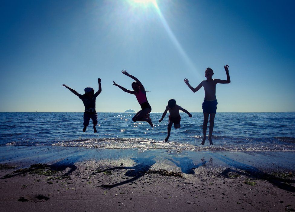 Children jumping at beach