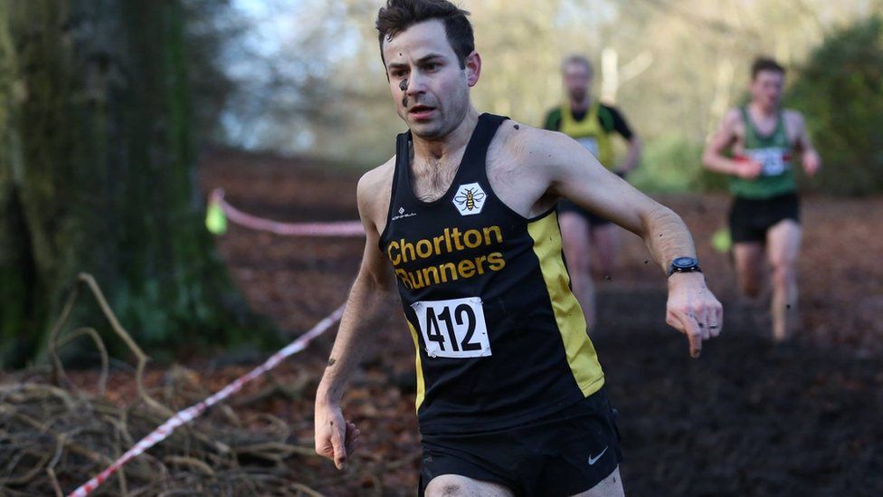 David Wyeth taking part in a cross country race, wearing his Chorlton Runners vest