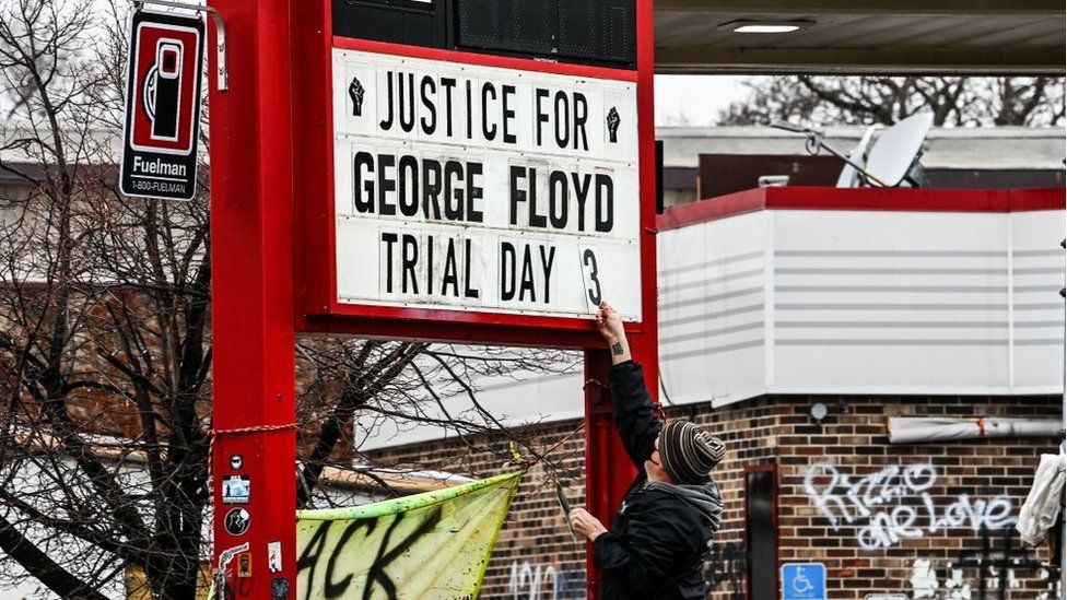 Мужчина меняет номер вывески на импровизированном мемориале Джорджа Флойда до того, как начнется третий день выборов присяжных на суде над бывшим офицером полиции Миннеаполиса Дереком Човеном