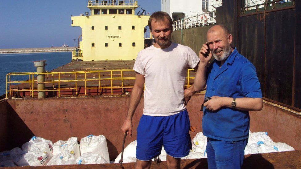 Boris Prokoshev (R), captain of the MV Rhosus, and boatswain Boris Musinchak pose next to a hold loaded with ammonium nitrate in the port of Beirut, Lebanon, in summer 2014
