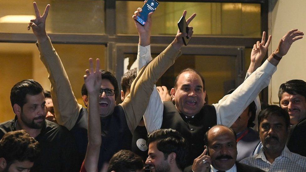 Opposition supporters celebrate outside the Supreme Court building after a court verdict in Islamabad on April 7, 2022. - Pakistan Prime Minister Imran Khan faces being booted from office at the weekend after the Supreme Court ruled on April 7 that parliament had been illegally dissolved and a no-confidence vote on his government must go ahead.