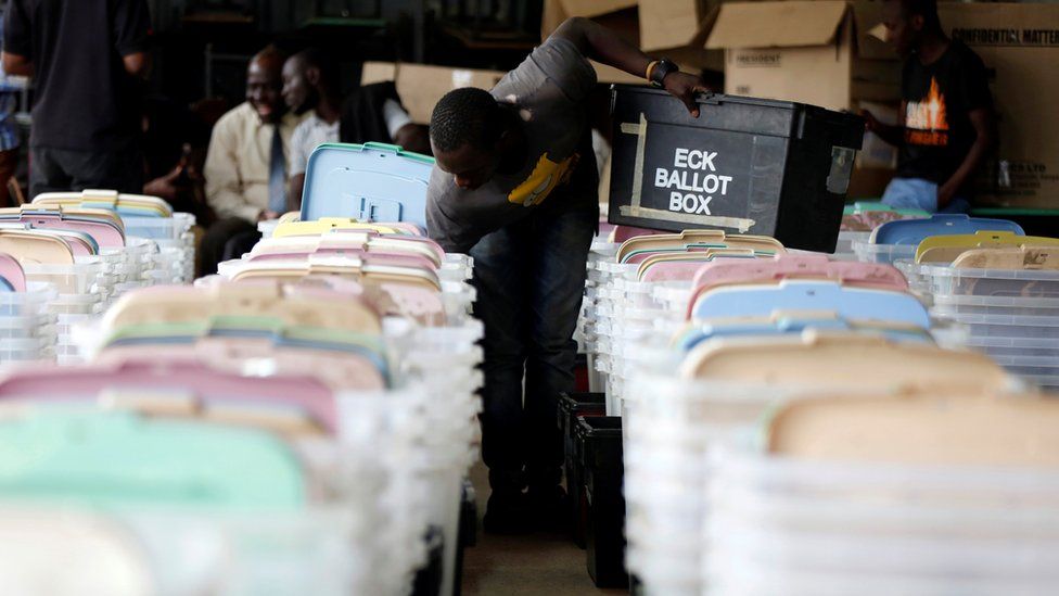 A Kenyan election tallying officer stuffs voting material into ballot boxes before they are transported to different polling stations in the Kibra Constituency at a tallying centre in Nairobi