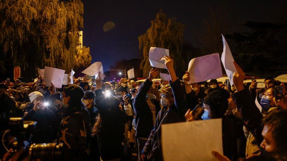 Протестующие размахивают чистыми белыми листами бумаги во время акции протеста, вызванной пожаром в Урумчи, в результате которого погибли 10 человек в Пекине, Китай, 27 ноября 2022 г.