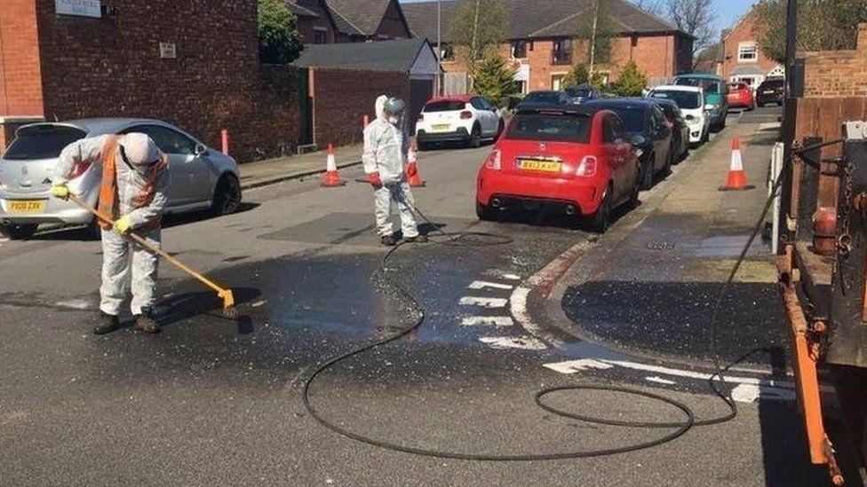 Council workers cleaning off wrongly spelt DIY road markings