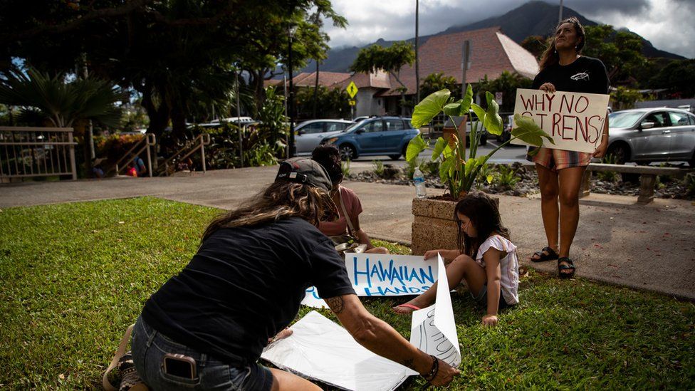 A protester holds a poster reading 'Why no Sirens?' as people demonstrate in front the Maui County Building where officials held a press conference, in Kahului, Hawaii, USA, 14 August 2023.