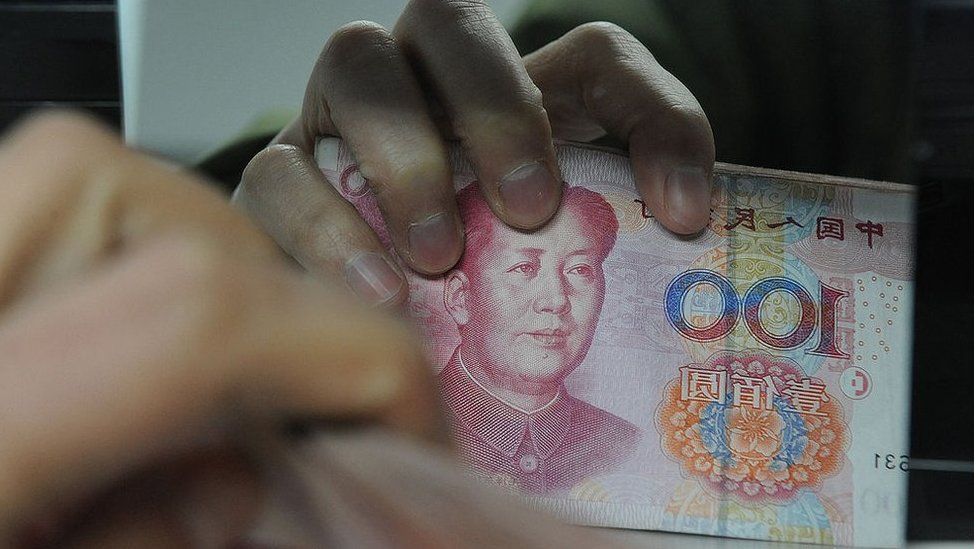 Chinese bank worker counts a stack of 100-yuan notes at a bank in Hefei, east China's Anhui province on 27 February 2011